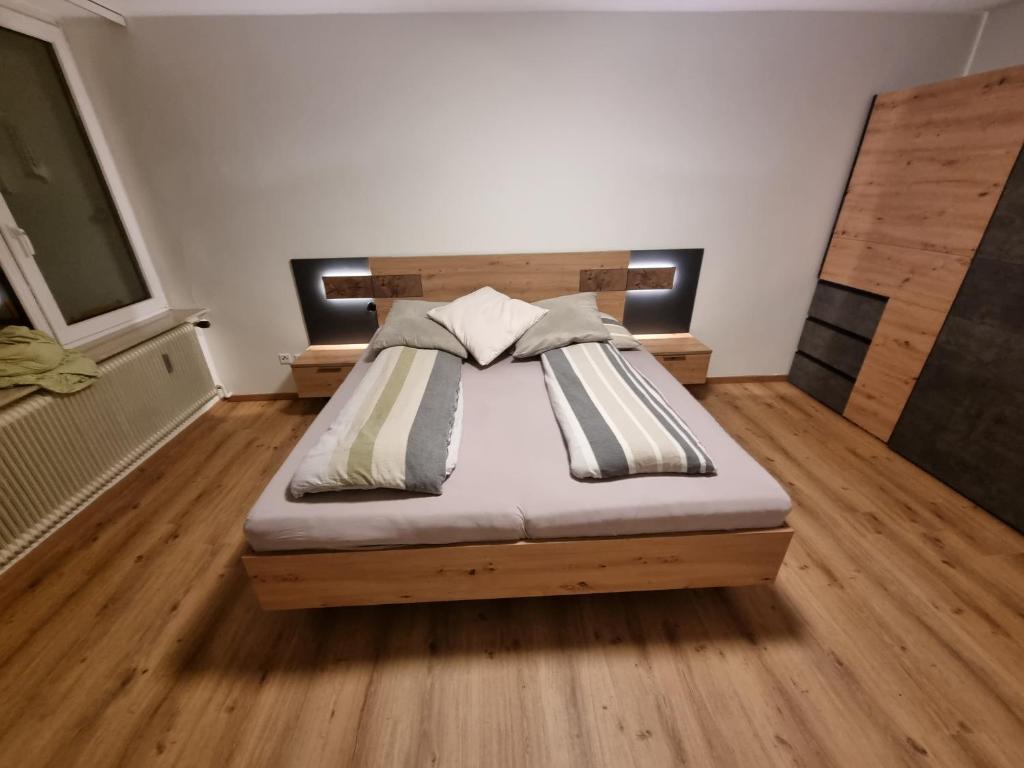 una camera con un letto in una stanza con pavimenti in legno di Gerlitzen, Kanzelhöhe, Über den Wolken, Haus Enzian a Deutschberg