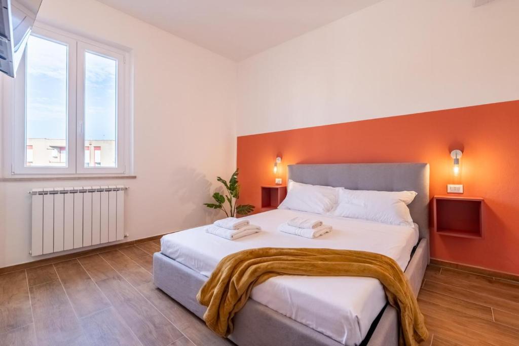 - une chambre avec un grand lit et un mur orange dans l'établissement Toli's guest, à Pise