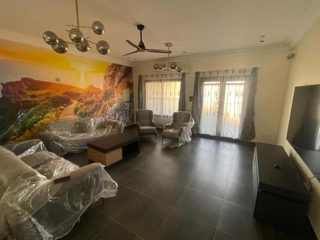 una sala de estar con una gran pintura en la pared en Furnished house of Véranda groupe, en Niamey