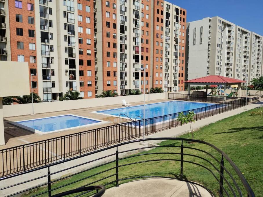 a swimming pool on top of a building with tall buildings at Apartamento Amoblado Alameda del Rio Barranquilla in Barranquilla