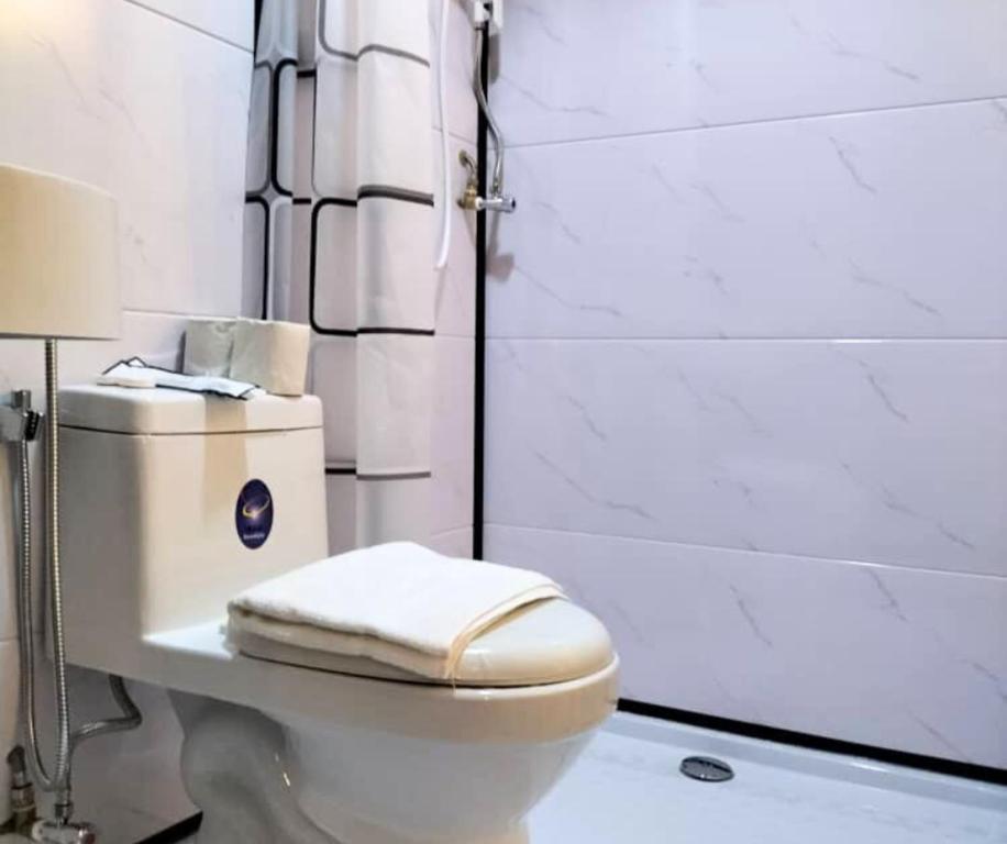 a bathroom with a toilet with a towel on it at Le Melur Single Bed in George Town