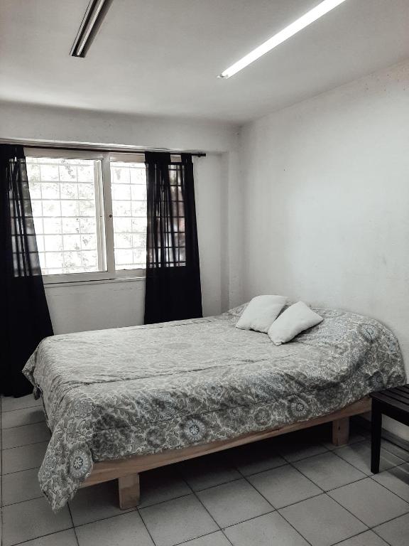 1 cama en una habitación blanca con 2 almohadas en Complejo Turístico Quinto Elemento 2 en San Rafael