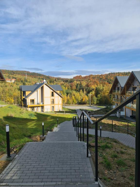 a walkway leading down to a house with houses at Apartamenty Czarne Owce in Szklarska Poręba