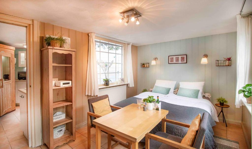 een slaapkamer met een bed en een tafel en een eetkamer bij B&B Noordzee-kerstdeco-Sauna-Strand7km-Kennemerduinen in Driehuis