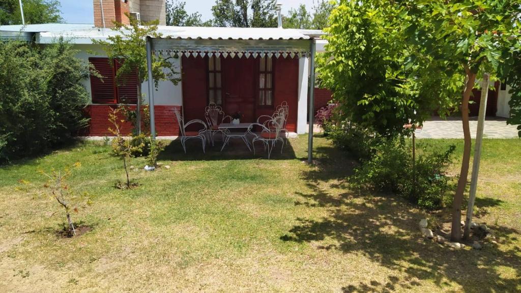 a patio with a table and chairs in a yard at El Chaparral Villa Dolores Traslasierra 3 in Piedra Pintada