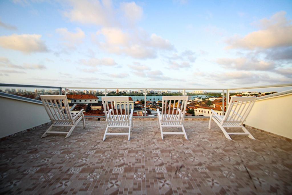 Hotel e Hostel da Fonte في ساو لويس: مجموعة من الكراسي موضوعة فوق الشرفة