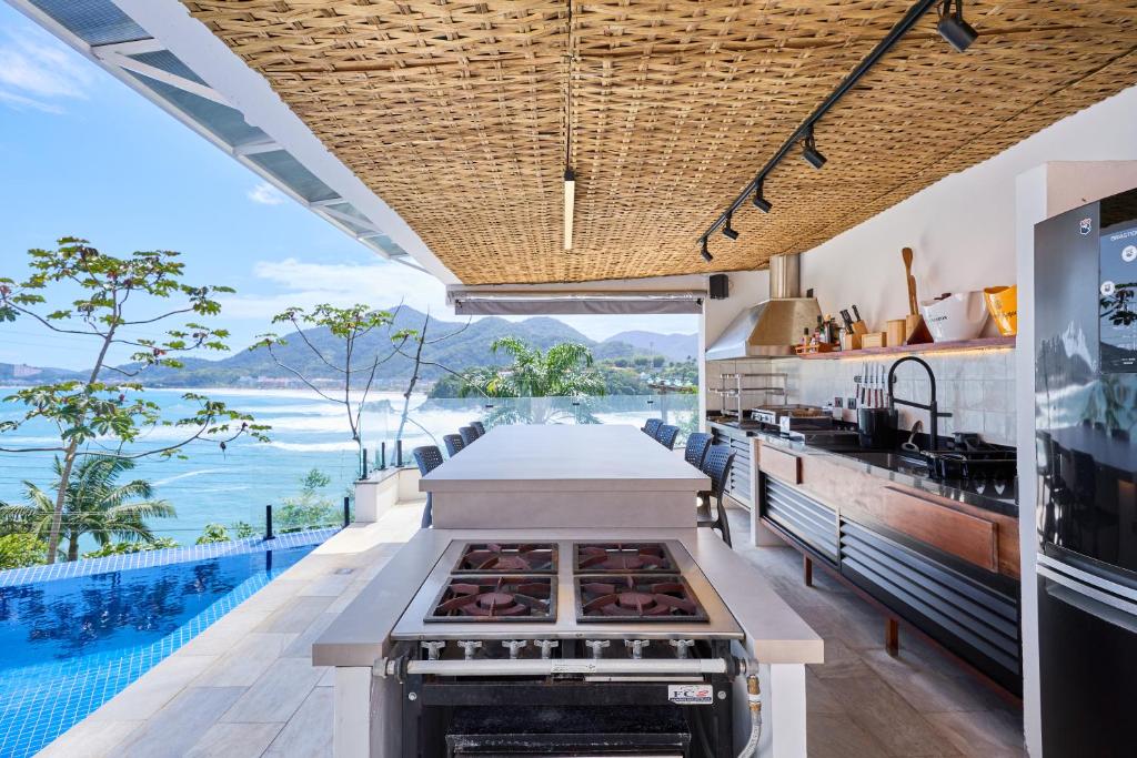 an outdoor kitchen with a view of the ocean at “Casa de alto padrão com ampla vista para o mar.” in Ubatuba