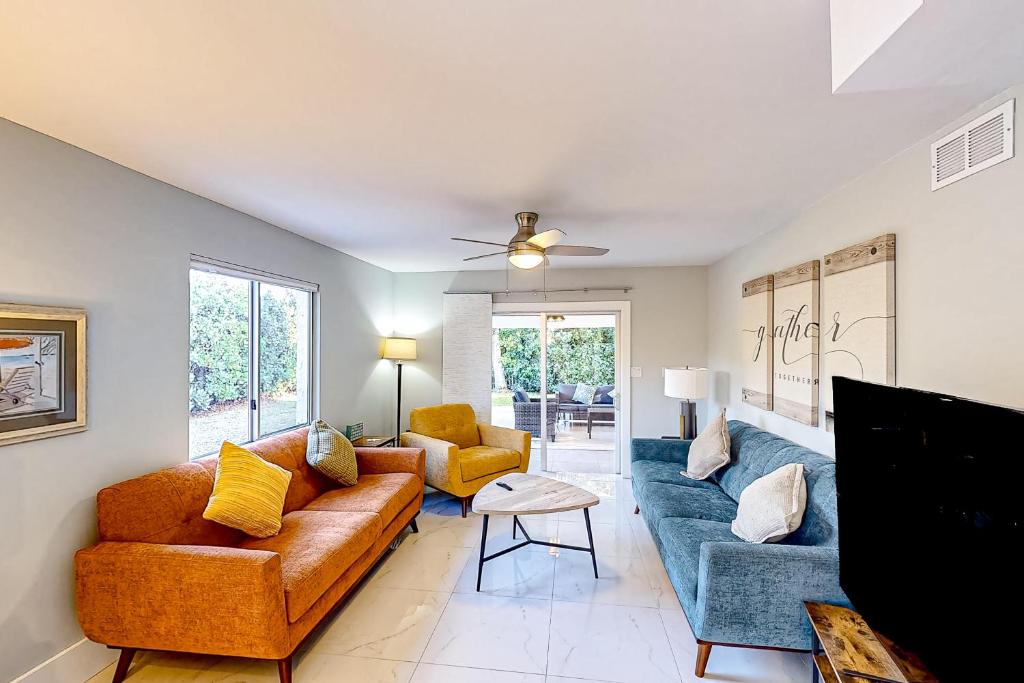 a living room with a couch and two chairs at Gather Together - Unit 145 in Marco Island
