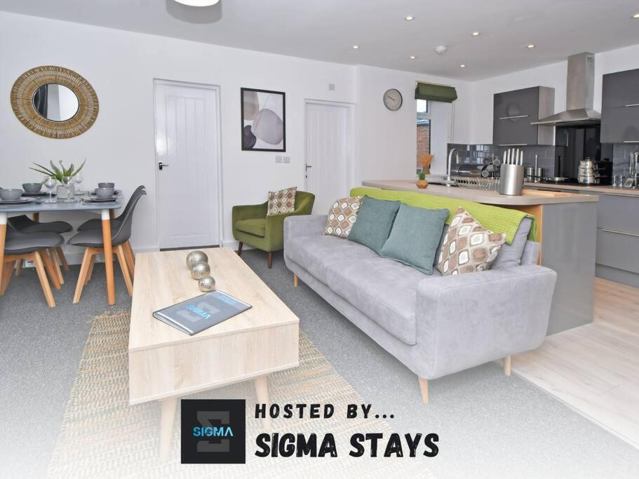 a living room with a couch and a kitchen at Lyndale Lofts - By Sigma Stays in Crewe
