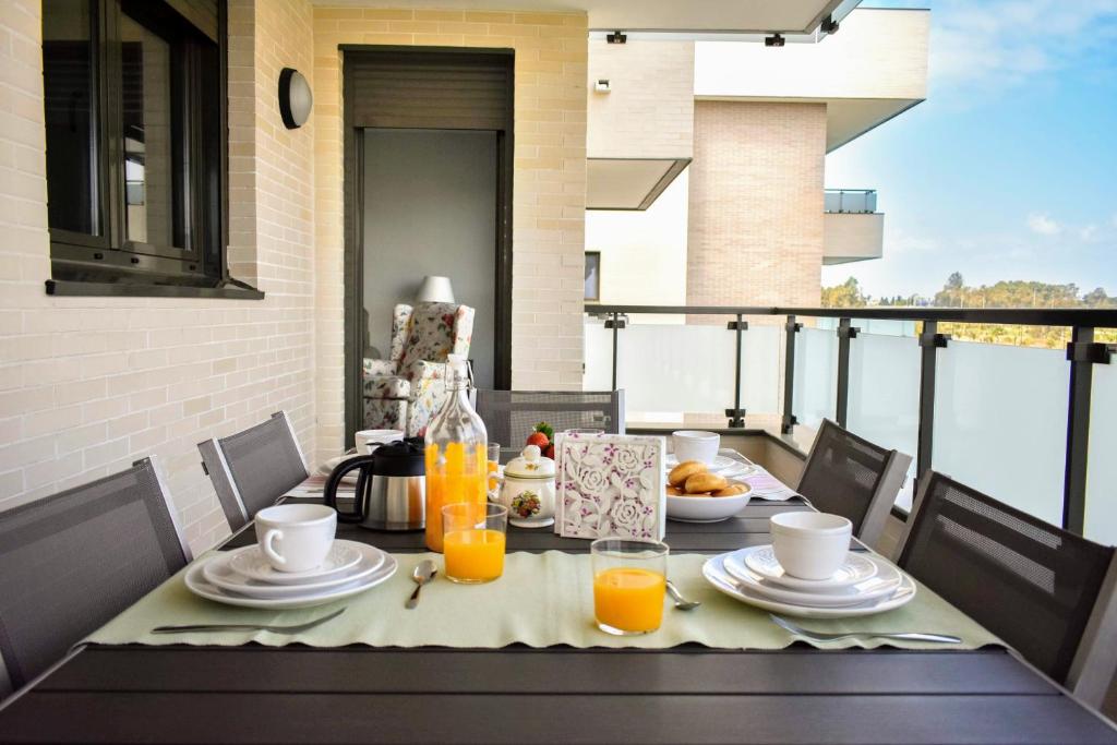 - une table avec de la nourriture et du jus d'orange sur un balcon dans l'établissement Los Alamos Beach - Parking, à Torremolinos