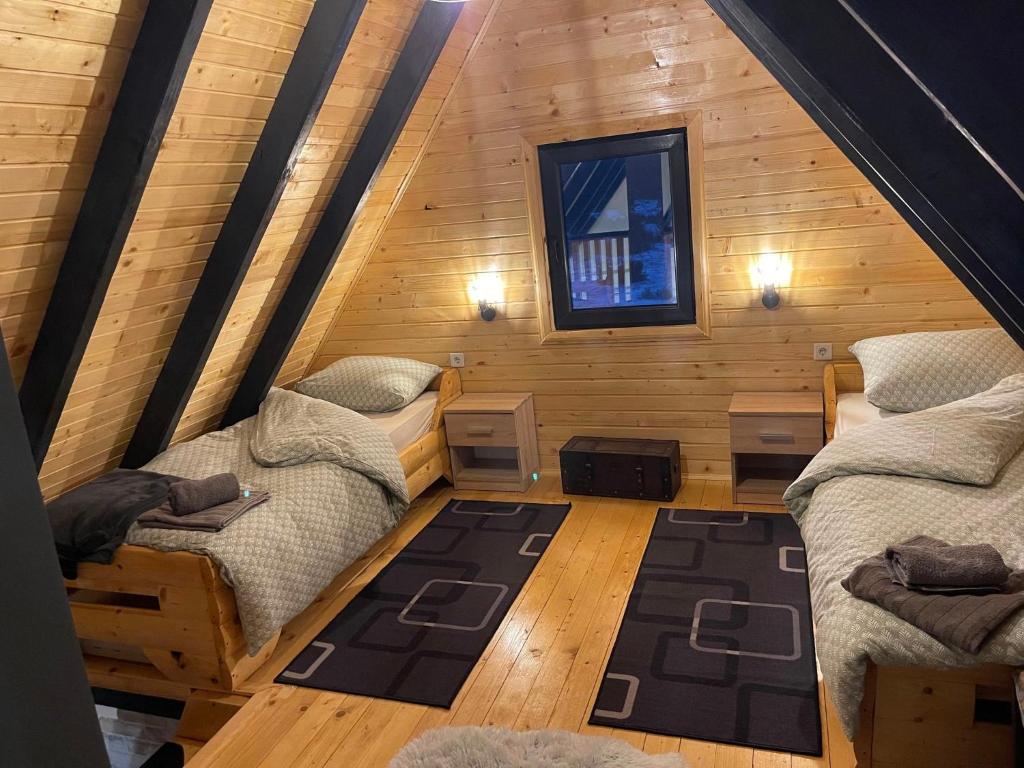 a room with two beds in a log cabin at Vikendica A&J in Blidinje