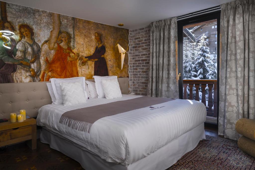 une chambre avec un grand lit avec un tableau au mur dans l'établissement Snow Lodge Hotel Courchevel 1850, à Courchevel