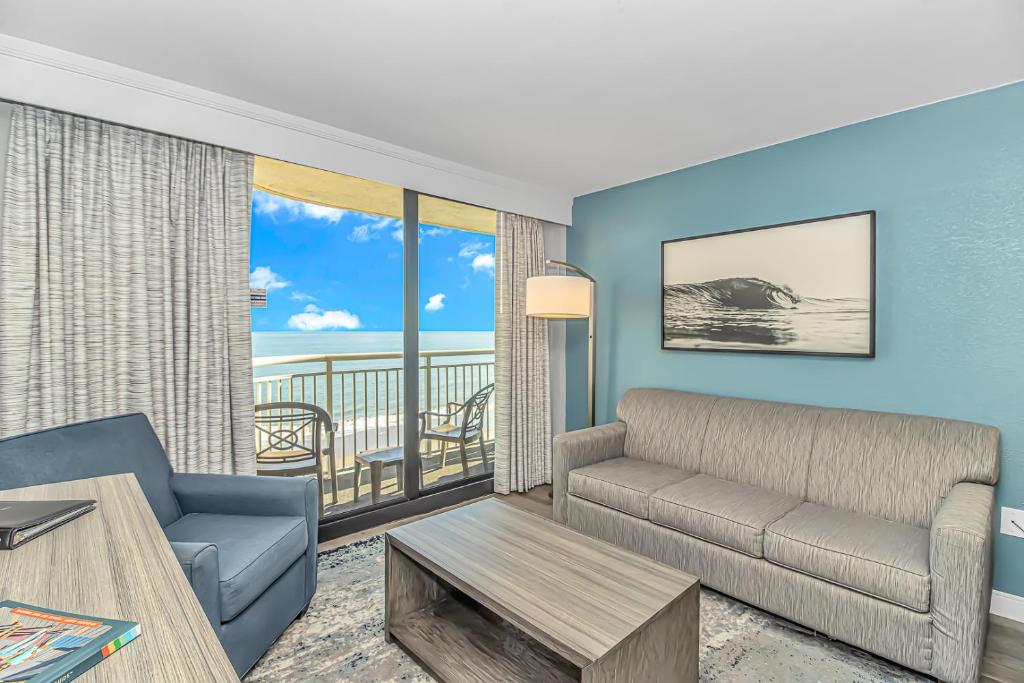 a living room with a couch and a table at Stunning Oceanfront 2 Bedroom Suite- Sailfish Resort 1111 in Myrtle Beach
