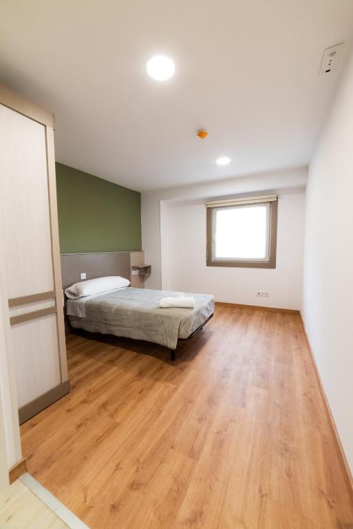 a bedroom with a bed and a wooden floor at ESTRELA DO CAMIÑO in Palas de Rei