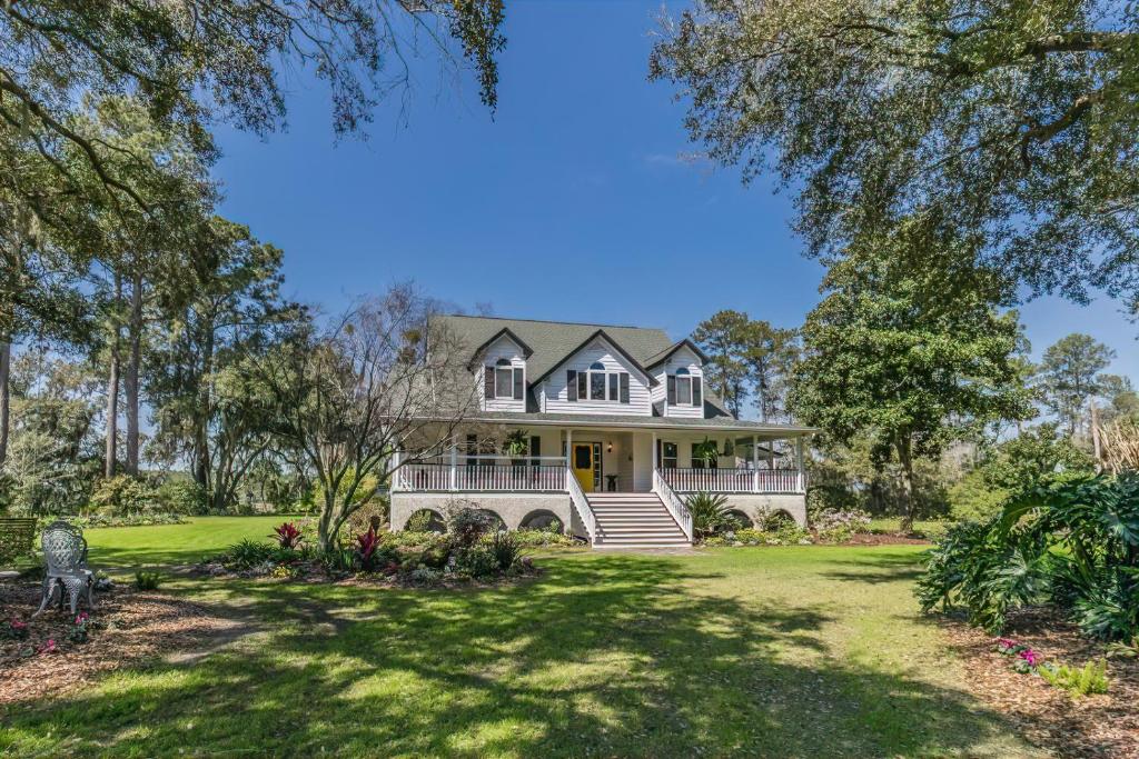 an exterior view of a large white house with trees at Private Retreat on Deep Water overlooking Jenkins Creek in St. Helena Island