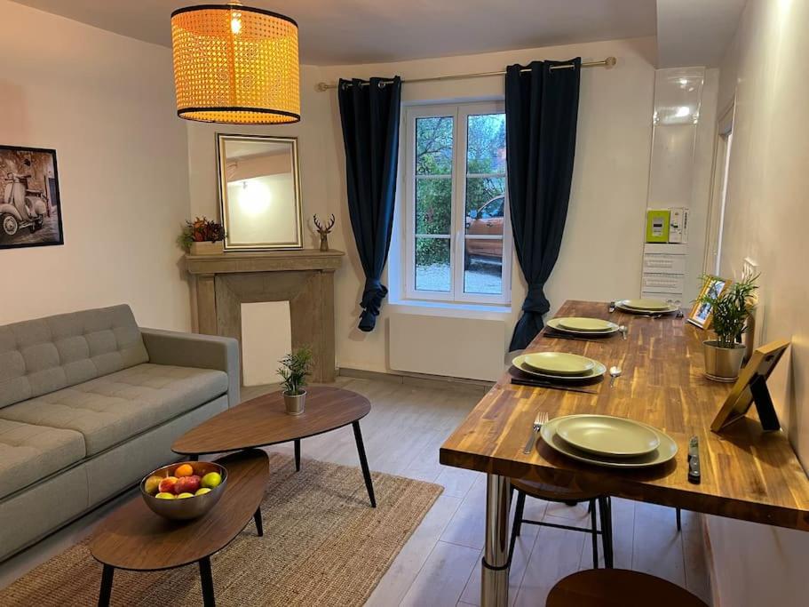sala de estar con mesa y sofá y sala de estar con mesa en La Mezzavilla, en Nuits-Saint-Georges