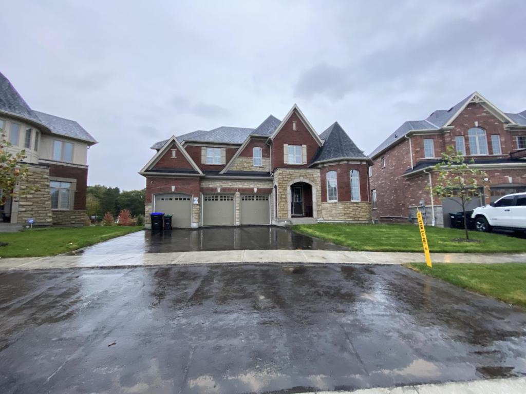 uma casa com um parque de estacionamento em frente em Snow Valley Hideaway em Barrie