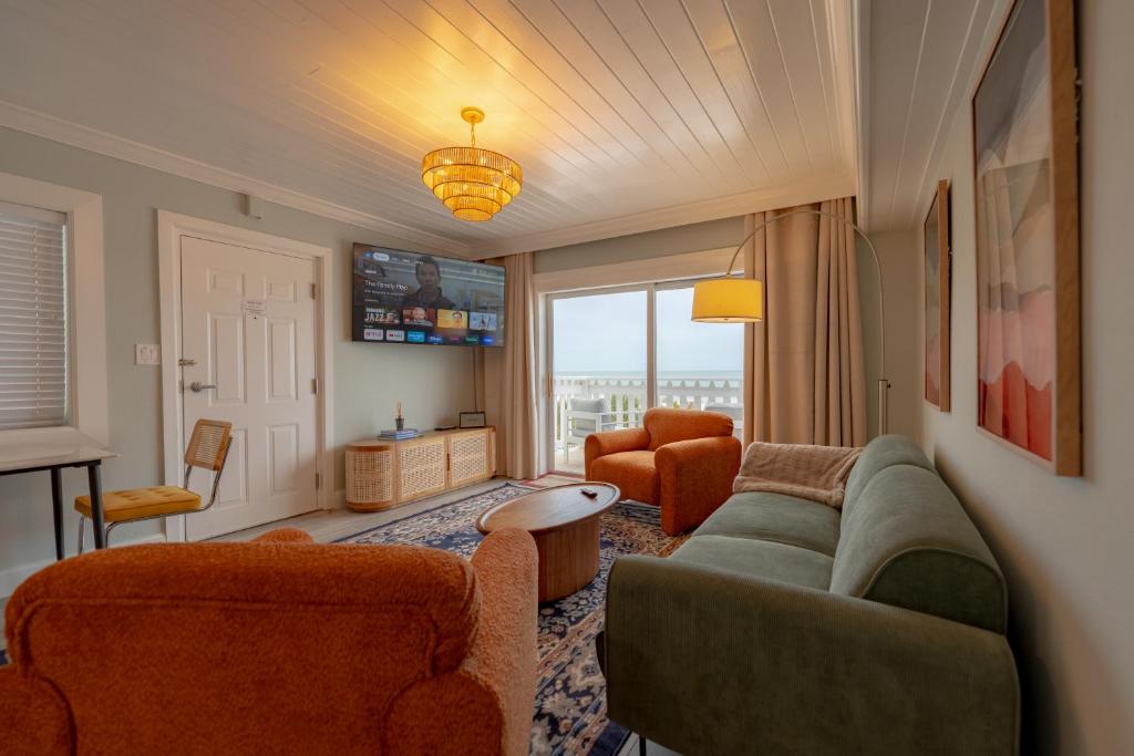 a living room with a couch and two chairs at Emerald on the Water - Formerly Belleair Beach Club in Clearwater Beach