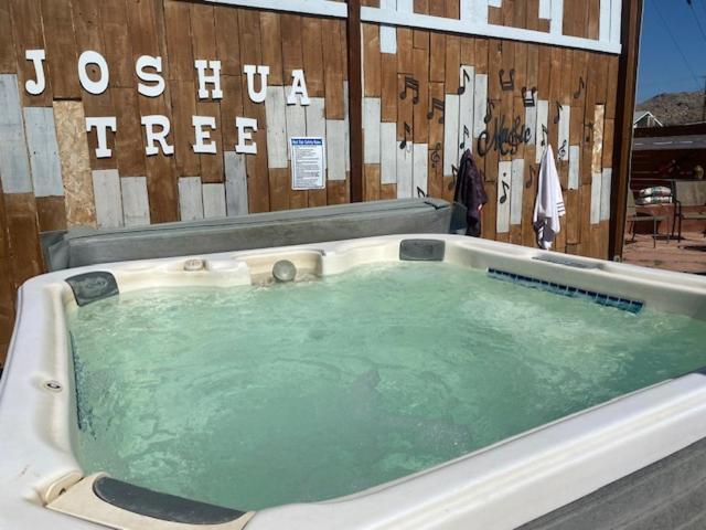 a bath tub filled with green water in front of a building at Casa De Frank in Joshua Tree