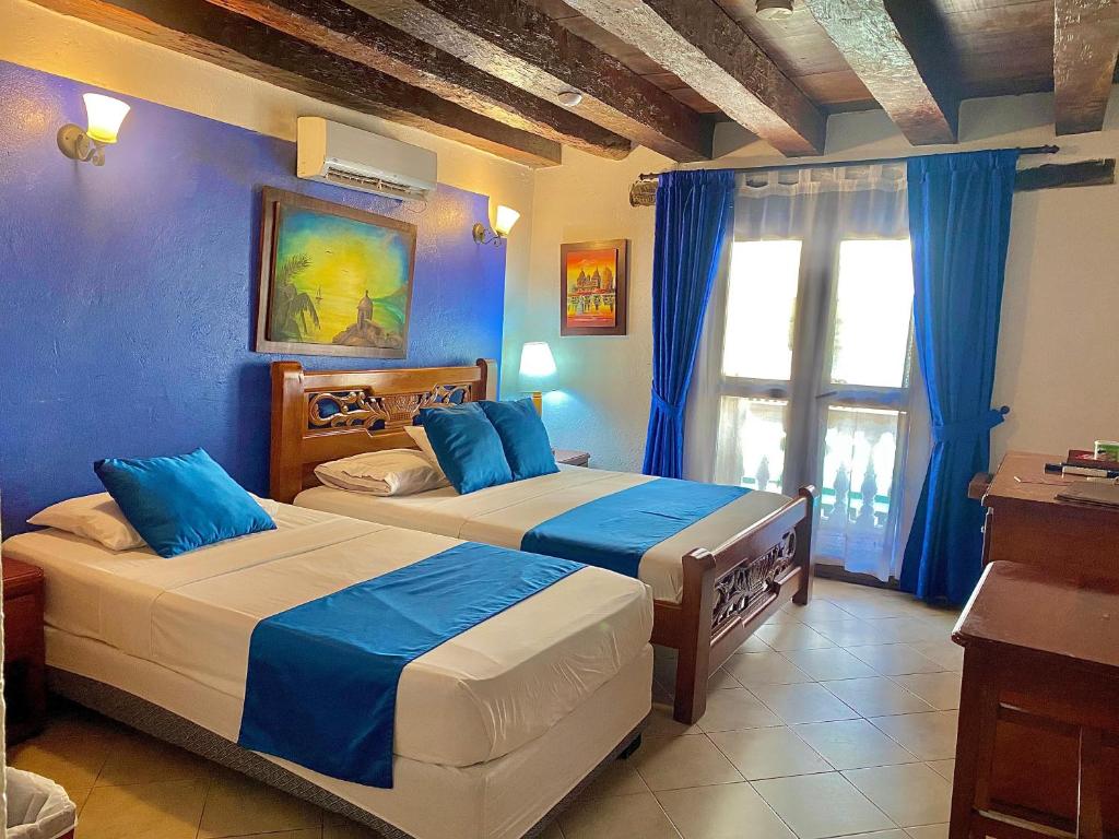 Postel nebo postele na pokoji v ubytování Hotel Don Pedro De Heredia
