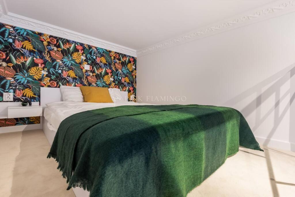 a bedroom with a bed with a green blanket at Elegant Stay Near Hungarian Museum by Pink Flamingo in Budapest