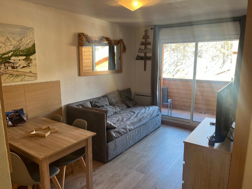 アロスにあるLa foux d allos Superbe appartement 6 couchages ,piscineのソファとテーブルのあるリビングルーム
