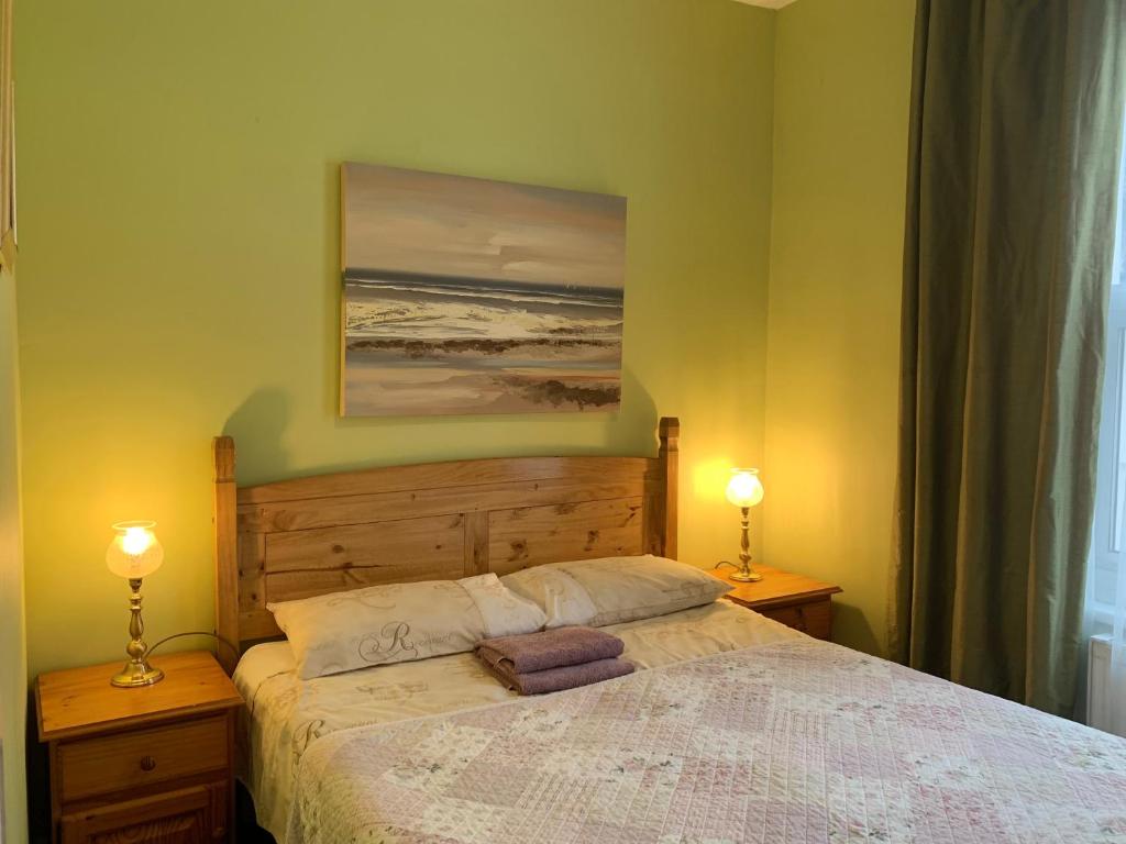 a bedroom with a bed with two lamps and a painting at Apartments near the sea with free parking Southend-on-Sea in Southend-on-Sea