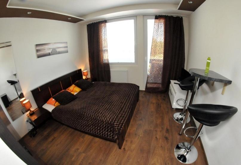 um quarto com uma cama, uma secretária e uma janela em Apartmány Šariš em Prešov