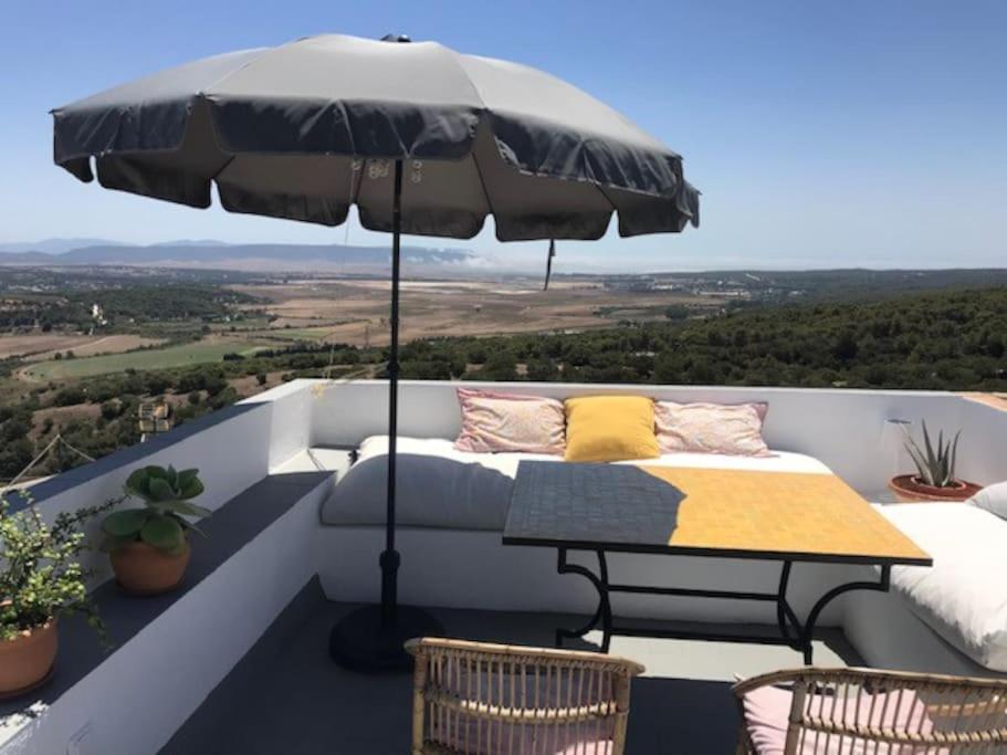 a patio with a table and an umbrella at La Niña de Vejer in Vejer de la Frontera