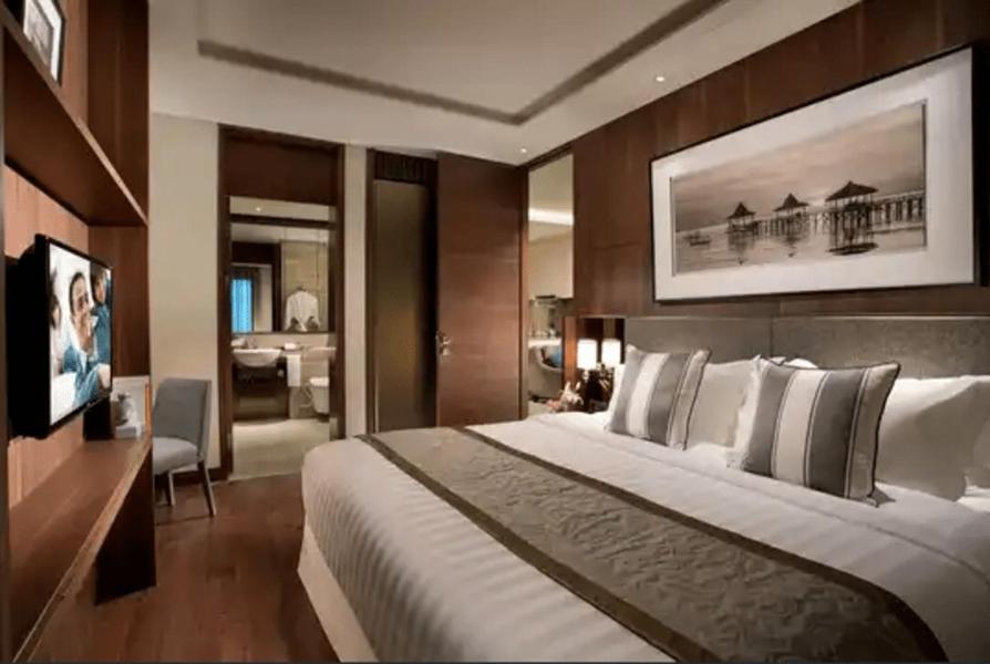 a hotel room with a large bed and a television at Luxury Apartement Rasuna Jakarta by Lentera in Jakarta