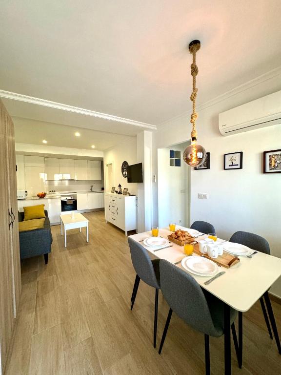 a dining room and living room with a table and chairs at La Zenia Boulevard & Beach House in Orihuela Costa