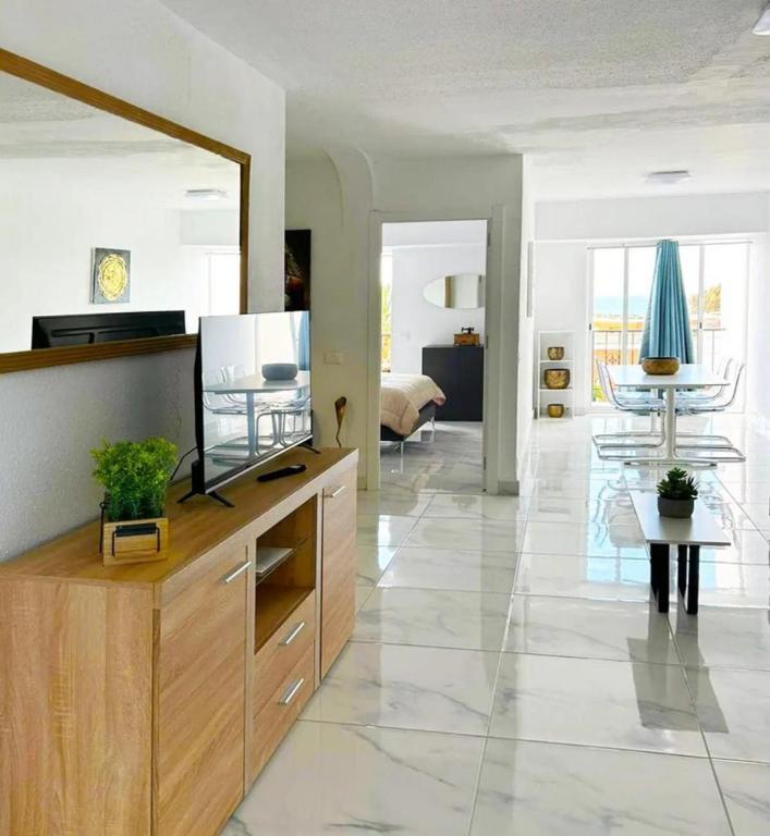 a living room with a large mirror and a television at La Casita de Bonnie in La Tejita