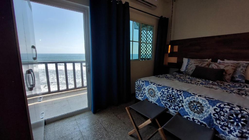 a bedroom with a bed and a view of the ocean at Sunset View 1-2 by Madriguera in La Libertad