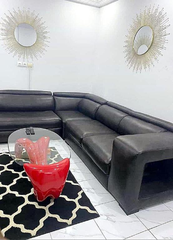 a living room with a black couch and a table at Residence Sighaka - Luxus VIP Apartment - WiFi, Gardien, Parking in Douala