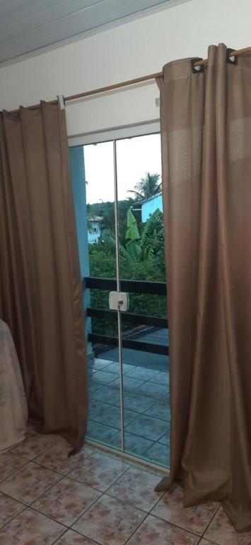 Una cortina en una habitación con vista a una ventana. en Quitinete no centro no segundo andar proxima a Rua das Pedras, en Búzios