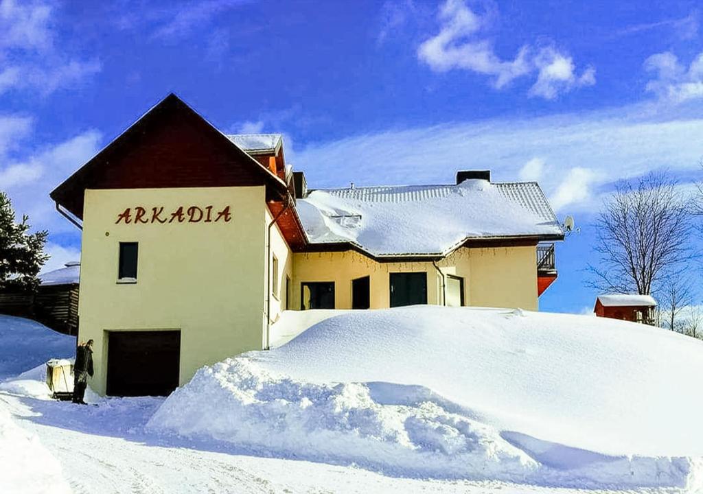 a house with a pile of snow in front of it at Arkadia in Muszyna