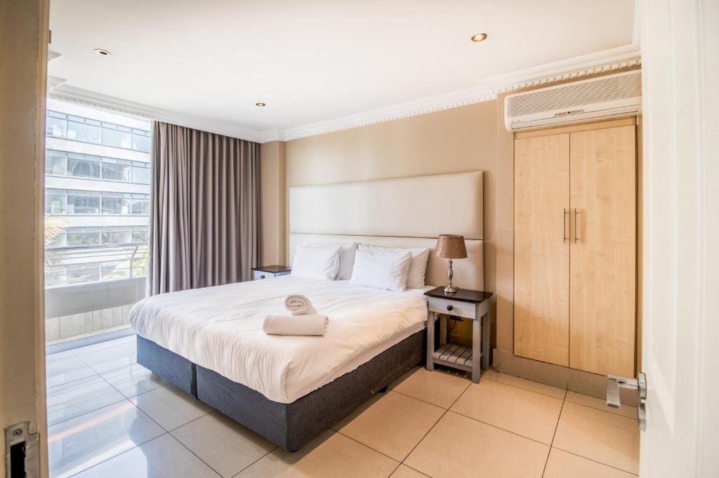 a bedroom with a large bed and a large window at Stunning Sails on Point C208 in Durban