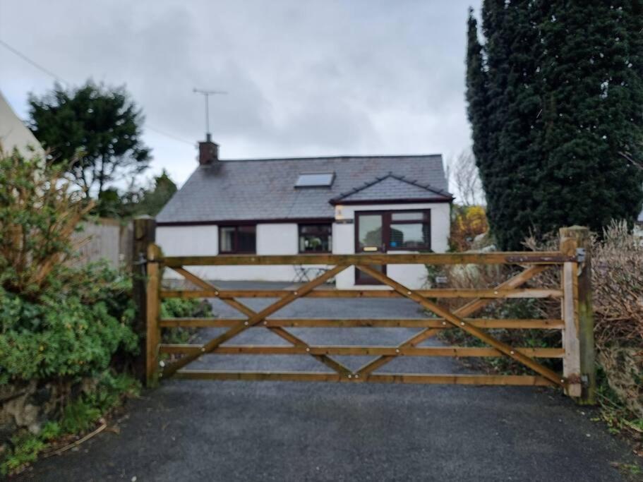 a house with a wooden gate and a fence at Cosy Cottage in Edern, Morfa Nefyn, Golf, Near Ty Coch in Ederyn