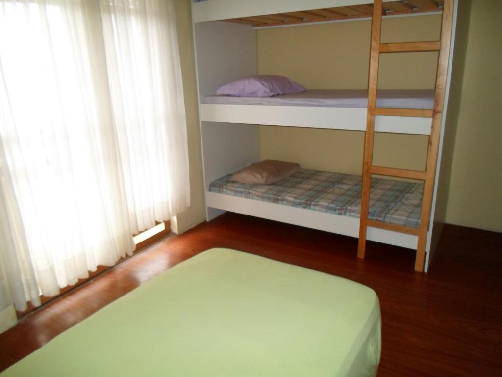 a room with two bunk beds and a ladder at Assel Pousada Xaxim in Curitiba
