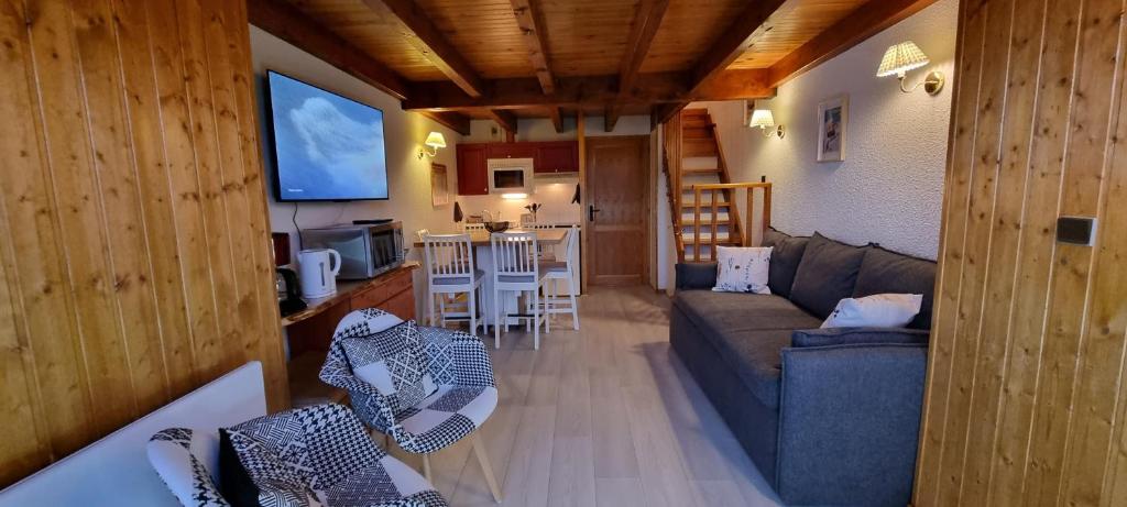 un salon avec un canapé et une cuisine dans l'établissement L'esprit chalet près des pistes, à Bolquère-Pyrénées 2000