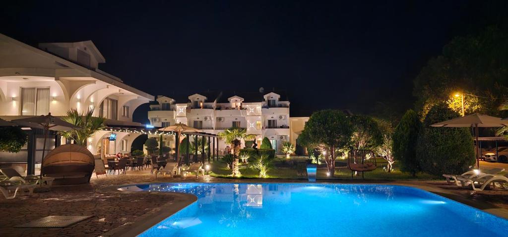 a swimming pool in front of a building at night at Hotel Comfort & Villas in Donji Štoj