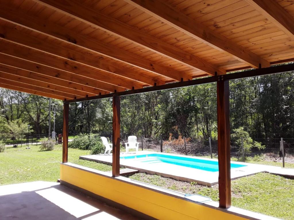 un pabellón de madera con piscina en un patio en Calamuchita Lodges en Villa Rumipal