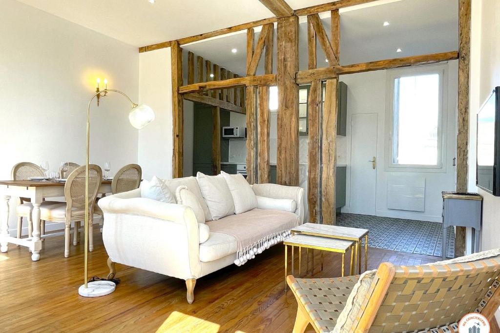 een woonkamer met een witte bank en een tafel bij L'Armateur - Confort - Standing - Marché in Le Havre