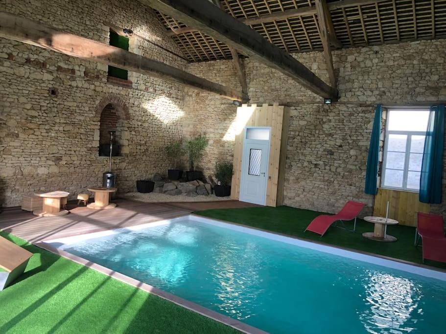 Amné-en-Champagne的住宿－Gite de charme avec piscine intérieure，一座砖墙建筑中的游泳池