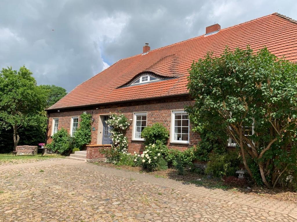 una casa de ladrillo con techo rojo en Nussbaumhof mit Koppel, en Plath