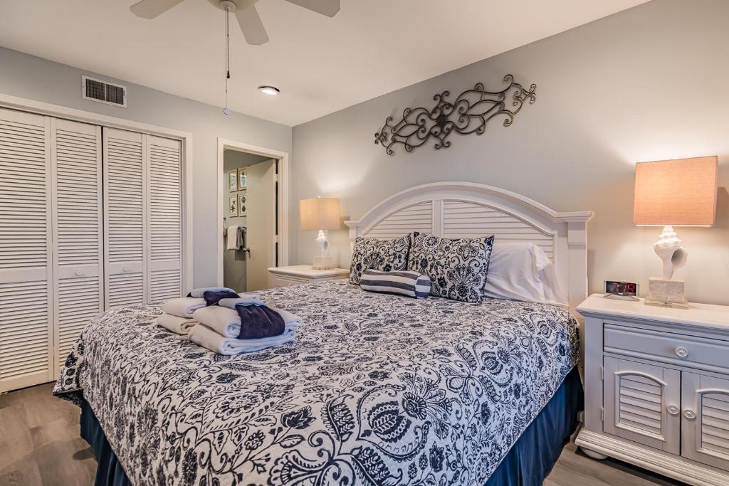 a bedroom with a bed with a blue and white comforter at Direct Ocean View! M Building Pool and Ocean Views in Harbor Island
