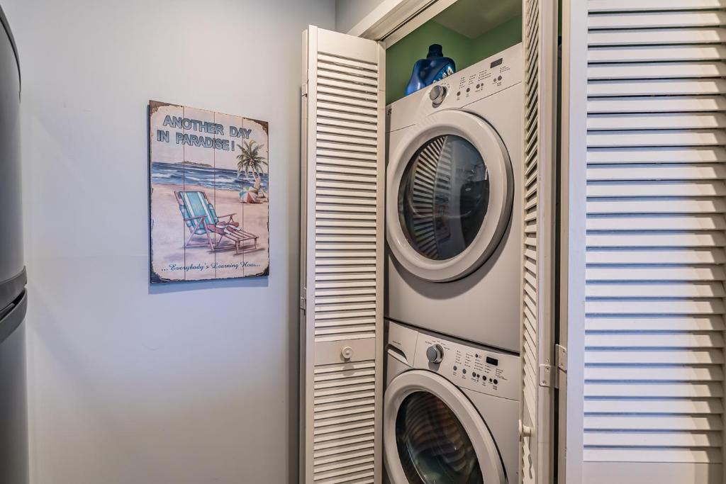 two washing machines in a room with a window at Direct Ocean View! M Building Pool and Ocean Views in Harbor Island