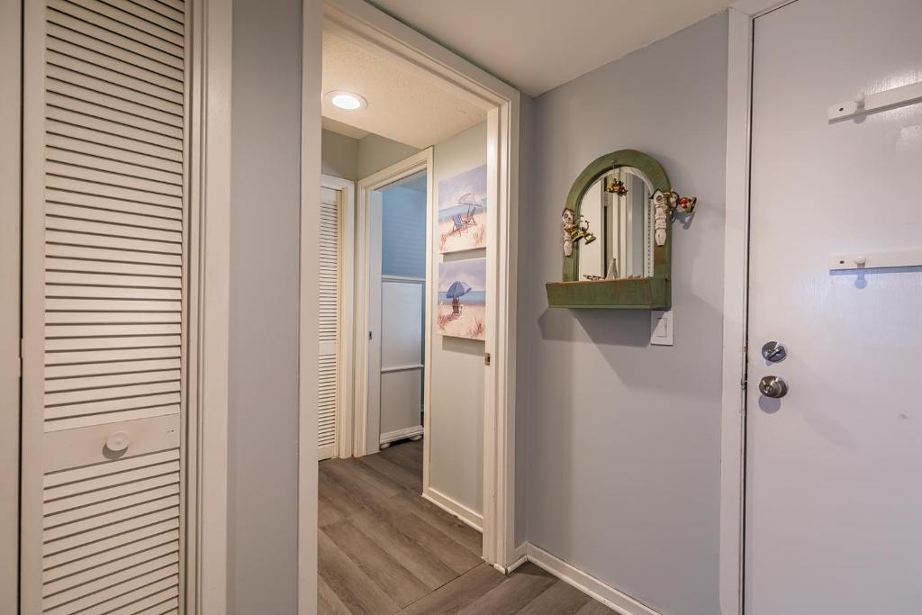 a hallway with a door leading into a room with a mirror at Direct Ocean View! M Building Pool and Ocean Views in Harbor Island