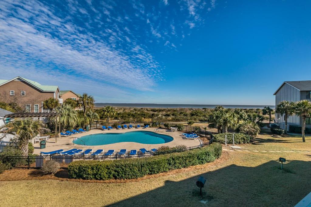 an overhead view of a swimming pool with chairs and palm trees at Direct Ocean View! M Building Pool and Ocean Views in Harbor Island