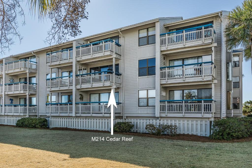 an apartment building with balconies and a flag at Direct Ocean View! M Building Pool and Ocean Views in Harbor Island